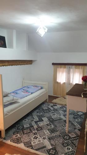 a bedroom with a bed and a table and a window at Facilitati cazare Raluca in Viscri