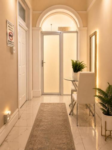 a hallway with a glass door and a table and chairs at Tiah Whyte, Durban in Durban