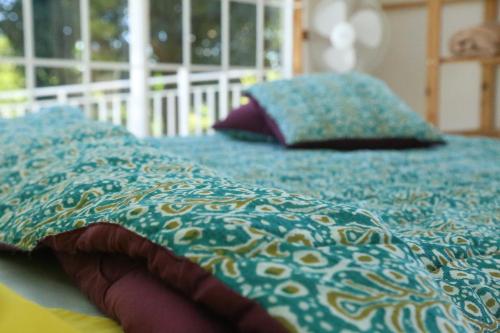 a bed with two pillows on top of it at L'Eden des Colibris in Vieux-Habitants