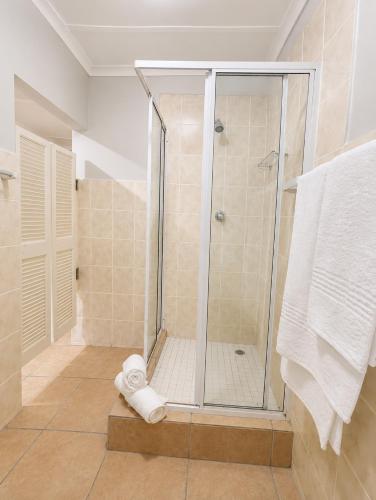 a shower in a bathroom with a glass shower stall at Tiah Grey, Durban in Durban