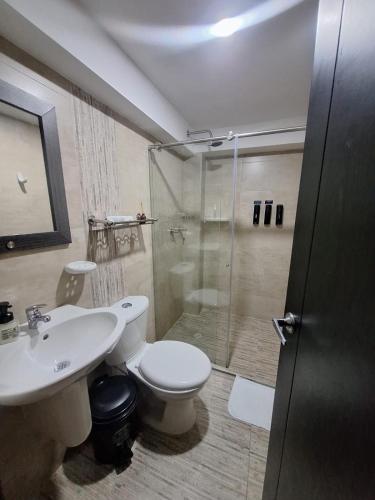 a bathroom with a shower and a toilet and a sink at Hotel San Blass Boutique in Pasto