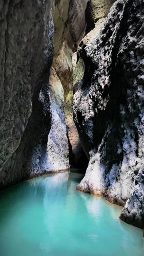 a pool of blue water in a canyon at Hermes Luxury Suites in Gramsh