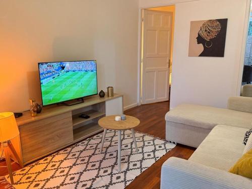 a living room with a flat screen tv on a entertainment center at Sunshine Privilège in Deshaies