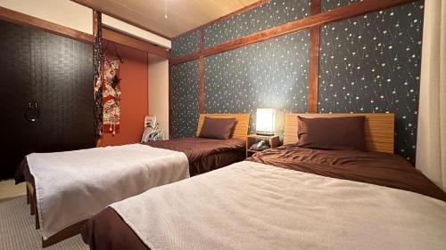 a bedroom with two beds and a wall with stars at 永山邸 in Asahikawa