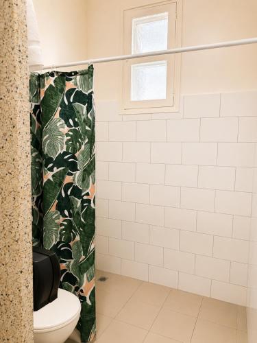 a bathroom with a toilet and a shower curtain at Pier Hotel Port Lincoln in Port Lincoln
