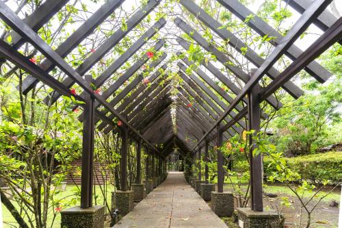 a wooden pergola in a garden with plants at The Glens Tagaytay in Kaybagal