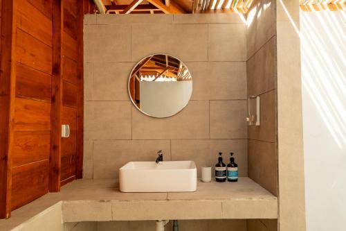 a bathroom with a sink and a mirror at Welly Bungalow in Gili Trawangan