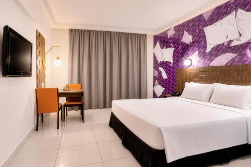 a hotel room with a large bed and a desk at Hotel Cassino Tower Piracicaba by Nacional Inn in Piracicaba