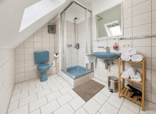 a bathroom with a blue toilet and a sink at Fewo ONE - by Europapark in Rust