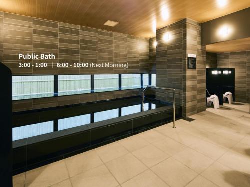 a swimming pool in a building with a sign that reads public bath at Hotel Intergate Hiroshima in Hiroshima