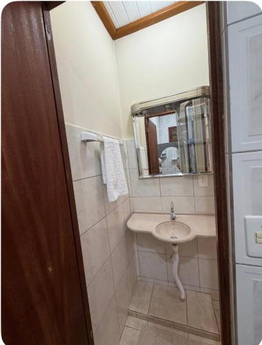 a bathroom with a sink and a mirror at Aconchego Anjo Helena in Domingos Martins