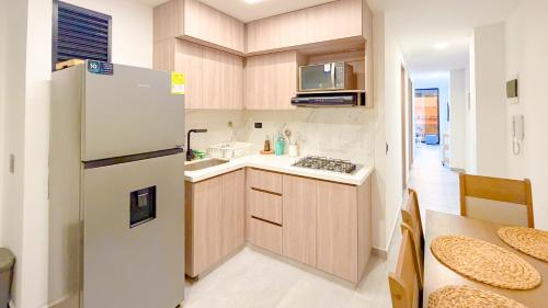a small kitchen with a refrigerator and a table at Apartamento Baruch IV in Itagüí
