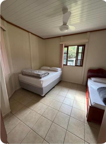 a bedroom with a bed and a window in it at Aconchego Anjo Helena in Domingos Martins