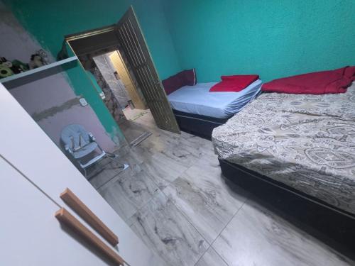 a room with two beds and a chair in it at Chácara pedaçoDcéu in Cavalcante