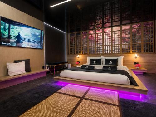 a bedroom with a large bed with purple lights at Grey Champagne Spa by Secret Apartament in Gdańsk