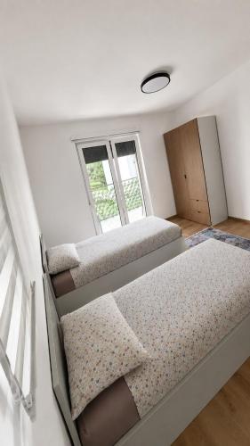 a bedroom with two beds and a window at Apartment Real in Bugojno