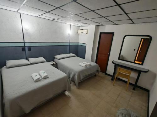 a hotel room with two beds and a mirror at El santa lucia in Panama City