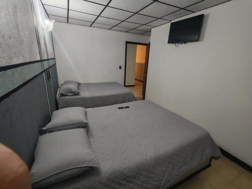 a room with two beds and a tv on the wall at El santa lucia in Panama City