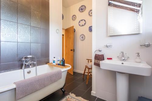 a bathroom with a bath tub and a sink at Picket Post House Accommodation in Catterall