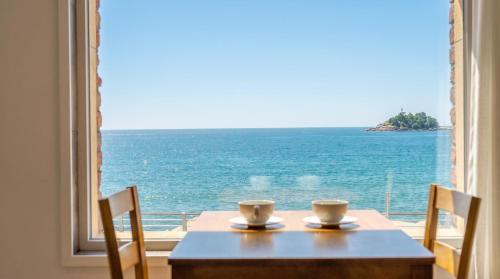 a table and chairs with a view of the ocean at Sokcho Moreve Pension in Sokcho