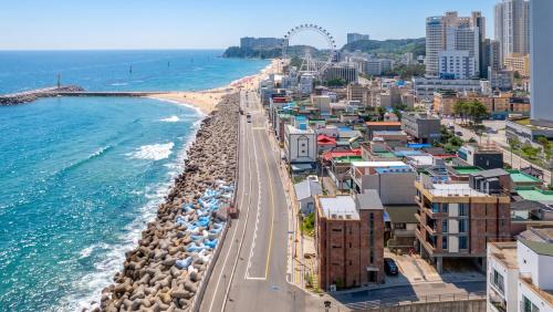 an aerial view of a beach with buildings and the ocean at Sokcho Moreve Pension in Sokcho