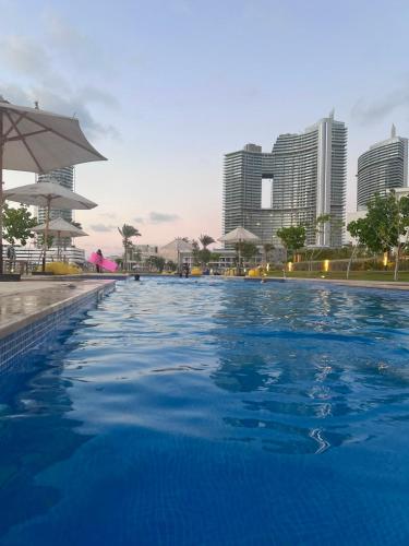 a swimming pool with a city in the background at العلمين الجديدة in El Dab‘a