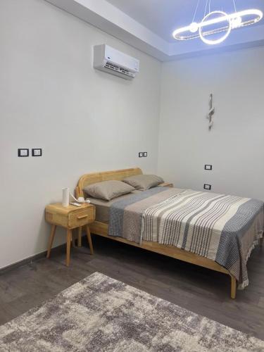 a bedroom with a large bed and a table at العلمين الجديدة in El Dab‘a