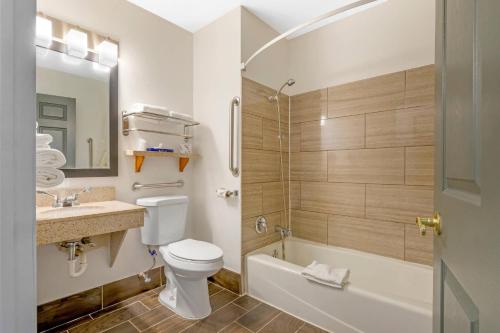 a bathroom with a toilet and a sink and a shower at Quality Inn Mauston I-90 in Mauston