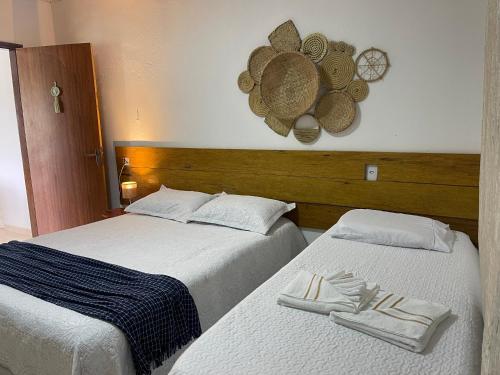 two beds sitting next to each other in a bedroom at Chalé Recanto da Coruja in Pão de Açúcar