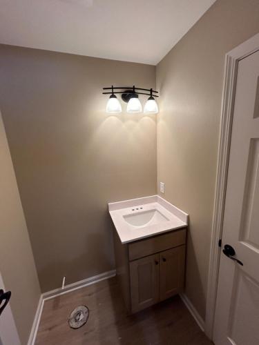a bathroom with a sink and two lights on the wall at KSK Getaway in Nekoosa