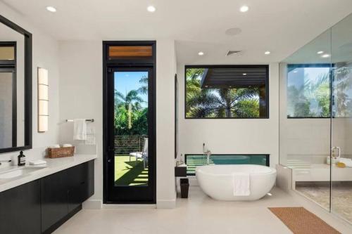a bathroom with a large tub and a sink and a tub at Villa Kahala Honolu With Pool in Honolulu