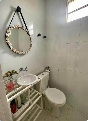 a bathroom with a white toilet and a sink at Chalé Recanto da Coruja in Pão de Açúcar