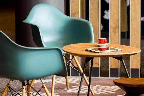 a table with a cup of coffee and two chairs at ibis Jerusalem city Center - An AccorHotels Brand in Jerusalem