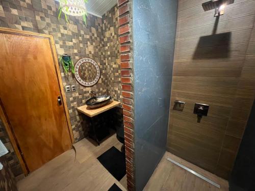 ein kleines Badezimmer mit Waschbecken und Dusche in der Unterkunft Casa Quinta Jurumi de La Mala Junta in Atyrá