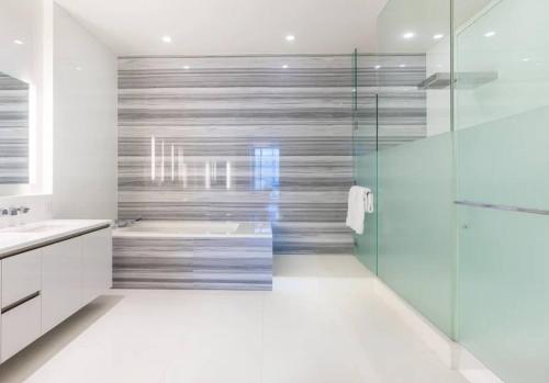 a bathroom with a shower and a sink and a tub at Sunset View Apartment Deluxe in Honolulu