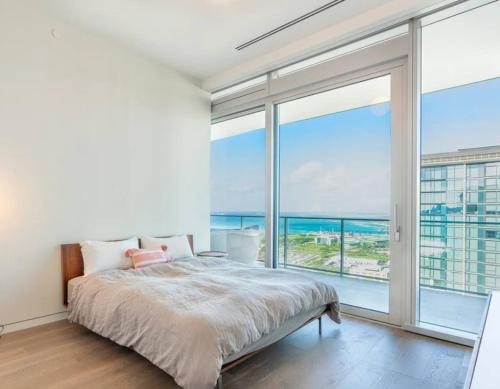 a bedroom with a bed and a large window at Sunset View Apartment Deluxe in Honolulu