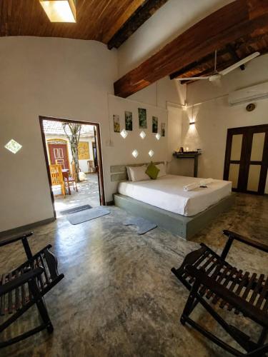 a bedroom with a bed and two chairs in it at Avalon Villa Unawatuna in Unawatuna