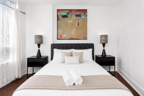 a bedroom with a white bed with two night stands at Luxurious 2BR 2BATH Condo Steps from Square One in Mississauga