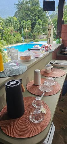 a table with plates and wine glasses on it at Pousada Paraíso Guapi in Guapimirim