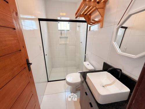 a bathroom with a toilet and a sink and a shower at Roraimar Prime Maragogi - Beira Mar in Maragogi