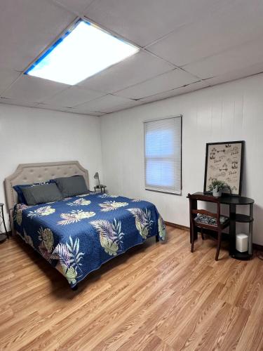 a bedroom with a bed and a table and a window at Downtown 2 BR Cottage Close to IU in Bloomington