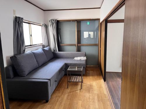 a living room with a blue couch and a table at 御宿空蝉 in Tokyo