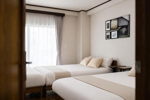 a hotel room with two beds and a window at HOTEL CtrlD ASAGAYA Spacious 130 Square Meter Apartment 4 Bedrooms 7 Beds 3 Minute Walk from JR Asagaya Station in Tokyo