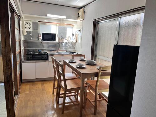 a kitchen with a wooden table and chairs in a room at 御宿空蝉 in Tokyo