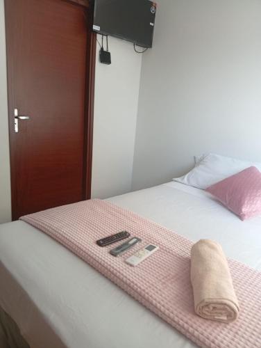 a bed with a pink towel on top of it at JG Hotel in Santa Cruz de la Sierra