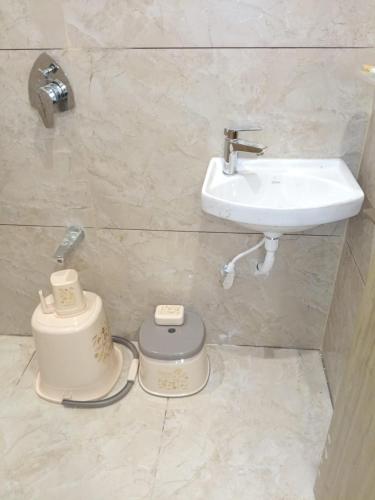 a bathroom with a sink and a toilet and a sink at Dwarka Home Stay in Dwarka