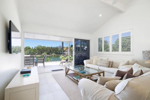a living room with a couch and a table at Noosa Haven Apt 12 Riverfront Elegance in Noosaville