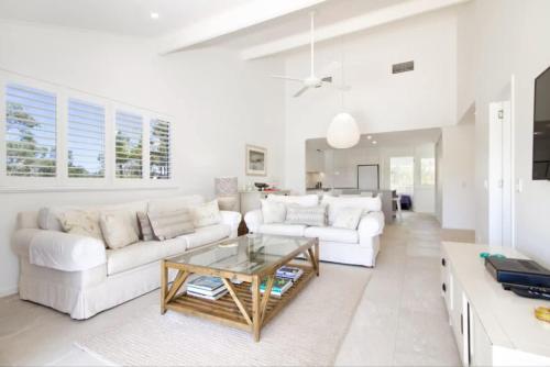 a living room with two white couches and a coffee table at Noosa Haven Apt 12 Riverfront Elegance in Noosaville