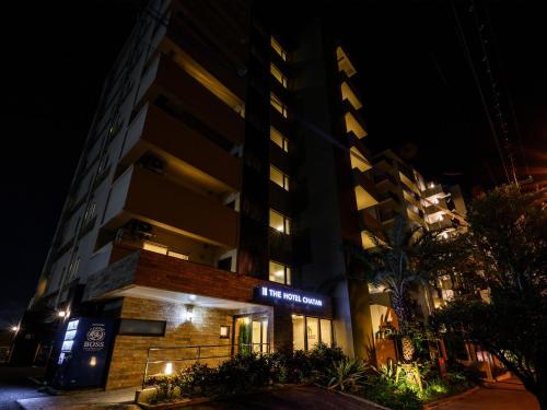 a tall building with a sign on it at night at The Hotel Chatan by Sunrest Resort in Chatan