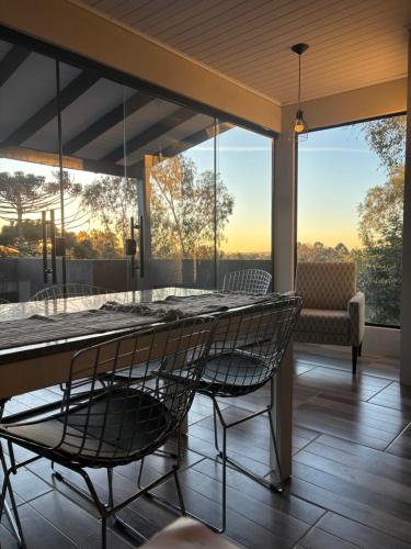 a screened in porch with a table and chairs at Casa vista do Vale in Farroupilha